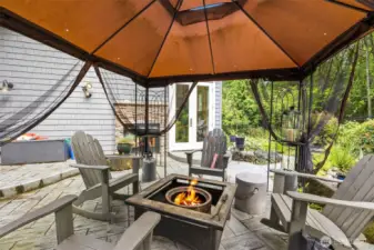 Enjoy the cozy back patio with a double-sided fireplace from the den.