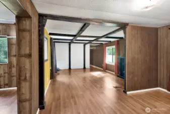 Living room area off the kitchen. Hallway toward the back right leads to bedrooms and bathroom.