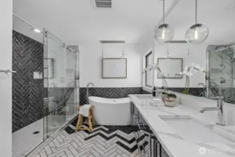 This spa-inspired bath features a large tub, spacious shower with two rain shower heads, and plenty of storage.