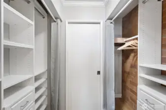 The primary bedroom’s large walk-through closet is flanked on both sides with custom built-ins that keep the wardrobe organized.