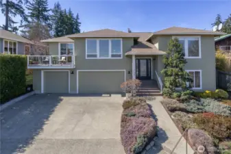 Front view of home with garden and sidewalk to the front door. Park in the garage, unload shopping into nearby storage.
