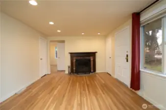 To the right of the door is a wood burning fireplace with 2 main floor bedrooms beyond.