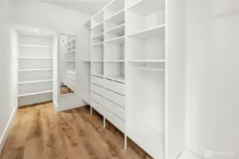 The large walk-in closet with a custom closet system in the primary suite.