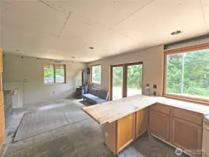 Looking out from the kitchen at the connected living/dining room. Wood stove is installed for cozy winter nights!