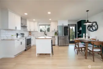 Bright, inviting kitchen-dining space with warm wood tones and layered natural and recessed lighting.