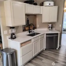 Kitchen has new countertop, back splash, and stainless steel sink