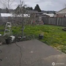 Fully fenced backyard with a fire pit.