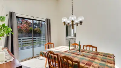 A stylish dining room featuring a glass door that opens onto the deck, perfect for indoor-outdoor entertaining.