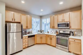 Another view of the open kitchen showcasing ample cabinetry, counter space, and full appliance layout.