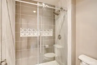 Ensuite bath with a modern, glass-enclosed shower.