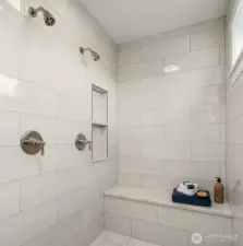 Primary bath with two walk in closets and beautiful tile work.