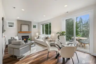 Step into the light-filled living and dining area, where newer flooring, a cozy gas fireplace, and custom built-in cabinetry create an inviting space to gather