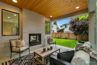 Covered back porch with cozy gas fireplace to enjoy quiet evenings at home.