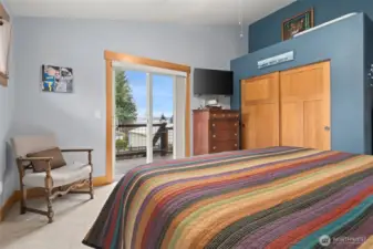 Primary Bedroom with sliding glass door allowing access to the wrap around deck and the incredible views of Stretch Point State Park and Mt. Rainier.