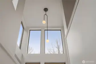 Modern lighting and expansive windows complement the high ceiling