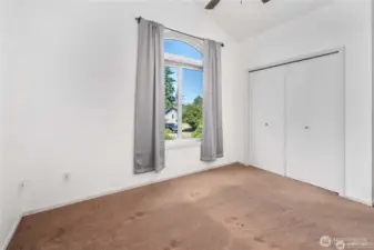 Upper level bedroom no. 1 with tall ceilings and a ceiling fan to circulate fresh air.