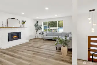 Bright, fully remodeled living room with fireplace, creating a warm and inviting space to gather!