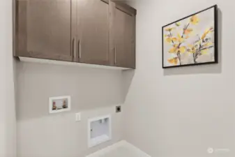 Convenient upstairs laundry room with storage cabinets