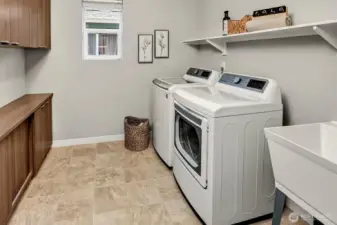 Upper utility room complete with W/D, utility sink and cabinets for storage