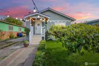 Adorable front porch with fruit trees and parking behind gate