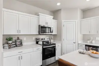 Modern shaker style cabinets and stainless-steel appliances. Actual home is under construction and finishes, colors, and materials may vary. See site agent for details.