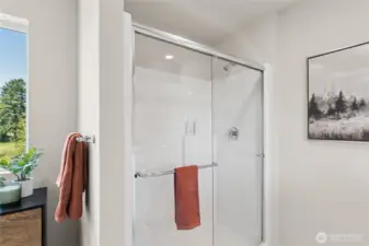 Step in shower with modern glass doors. Actual home is under construction and finishes, colors, and materials may vary. See site agent for details.