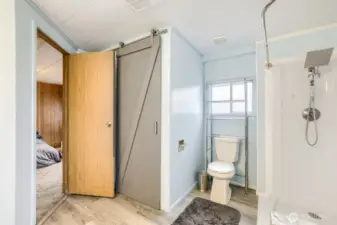 Ensuite primary bathroom with barn door closet