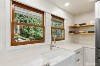 The kitchen overlooks the peaceful backyard setting.