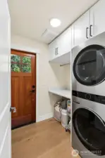 Laundry room with built-in cabinets; washer and dryer included.