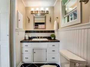 Freshly painted and thoughtfully refreshed, this inviting primary bath features stylish tile floors, classic beadboard, and elegant chair rail accents. With ample storage and updated lighting, it offers both charm and functionality.