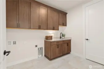 This spacious Laundry room makes washday a joy! with cabinetry to hide all of your laundry needs and Counter space for folding.