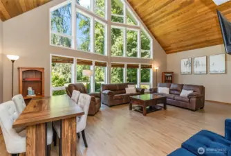 Fantastic living room with full wall of windows and beautiful tongue-in-groove pine ceiling.