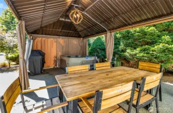 Ready for any weather, this covered patio includes dining space and a hot tub. Imagine relaxing or entertaining in this private sanctuary.