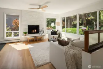 The living room is bathed in natural light from the large framed picture windows.