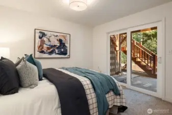 SW lower level bedroom with slider to patio and gardens.