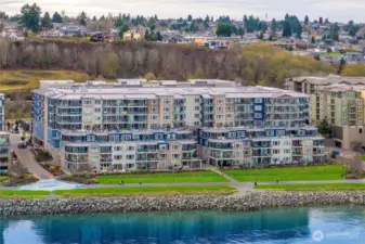 A detailed aerial look at the Baker Building positioned just steps from wide open green spaces, the waterfront promenade, and coastal pathways. The setting offers a unique blend of nature, activity, and urban convenience right outside your door.