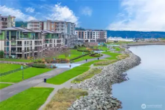 Beautiful aerial imagery displays the expansive greenbelt and shoreline walking paths that define the Point Ruston experience. This community is designed for enjoying the outdoors—morning strolls, waterfront jogs, or simply taking in the bay’s natural beauty.