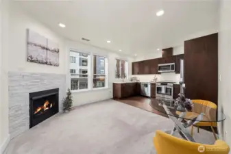 This view highlights the seamless connection between the living area and kitchen, offering an open layout ideal for everyday comfort. Recessed lighting and neutral finishes keep the space bright and inviting throughout the day.