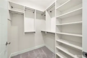 The primary suite includes a large walk-in closet equipped with extensive shelving and multiple hanging sections, providing organized storage for clothing, accessories, and daily essentials.
