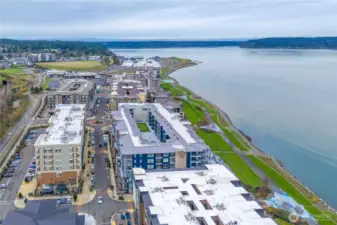 This elevated perspective captures the lively Point Ruston village area and the scenic waterfront trail that stretches for miles. Residents love the convenience of walking to shops, entertainment, and recreational paths with panoramic bay views.