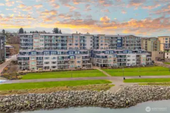 This waterfront view highlights how the Baker Building enjoys breathtaking evening skies over Commencement Bay. The surrounding parks and open spaces reflect the relaxed, outdoor-friendly lifestyle Point Ruston is known for.