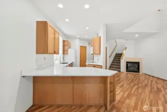From dining room looking straight on to kitchen with living room off to right and staircase just beyond. Laminate hardwood flooring throughout main floor.