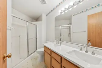 Primary en-suite 3/4 bathroom upstairs. update countertops and double undermount sinks with new hardware. Vinyl flooring cover. Shower includes a handheld shower head.