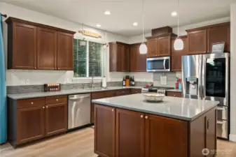 Large kitchen with stainless appliances and LVP flooring. Middle island provides extra storage and counter space in the kitchen.