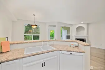 Kitchen is open to dining and living room with views beyond to the deck and greenbelt