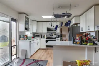 Kitchen with eat-in bar connects to a sliding door going out to the  Backyard deck.