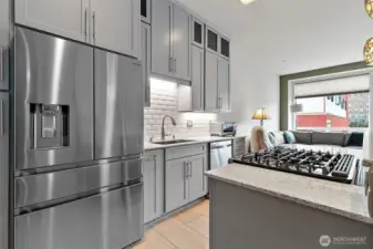 A five burner gas cooktop/oven with downdraft is perfect for home chefs who love precision cooking.  The four drawer refrigerator has a built-in ice maker and water dispenser.