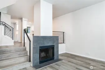 Bright and inviting living room featuring a cozy fireplace, modern finishes, and an open flow to the kitchen.