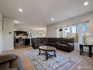 Spacious living room with abundant natural light, open to the kitchen and dining area, creating a bright and airy flow perfect for relaxing or entertaining.
