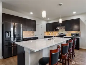 A spacious kitchen island offers abundant seating, making it ideal for entertaining and socializing while cooking.